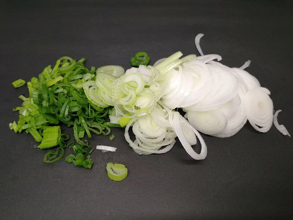Cebolla tierna cortada a rodajas.