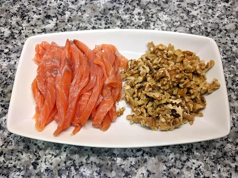 Salmón ahumado a tiras y nueces a trozos.