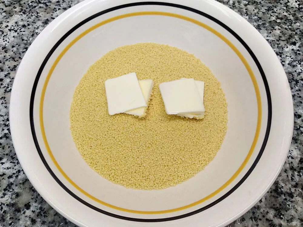 Cuscús y mantequilla en cuenco.