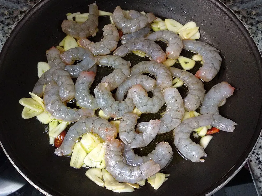 Langostinos, ajos laminados y guindilla.