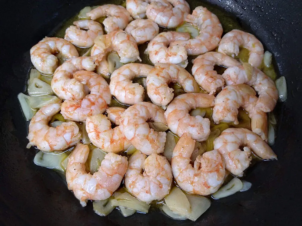 Langostinos, ajos laminados y guindilla salteados.