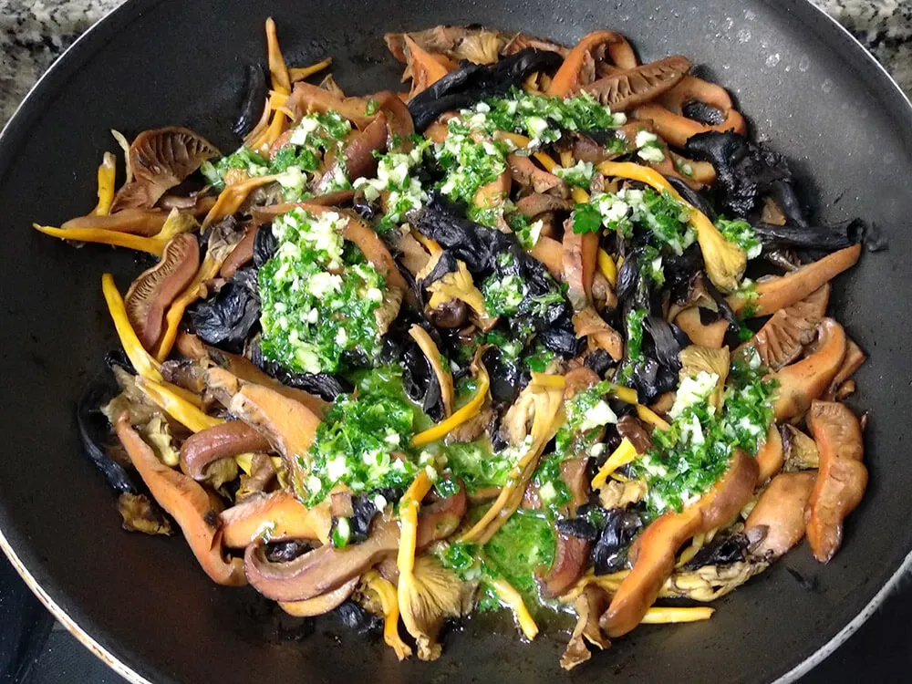 Setas en sartén con aceite de ajo y perejil.