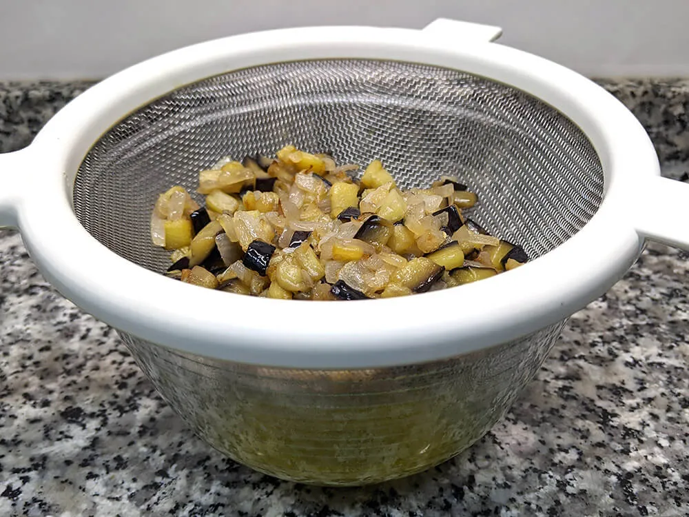 Cebolla y berenjena fritas en colador.