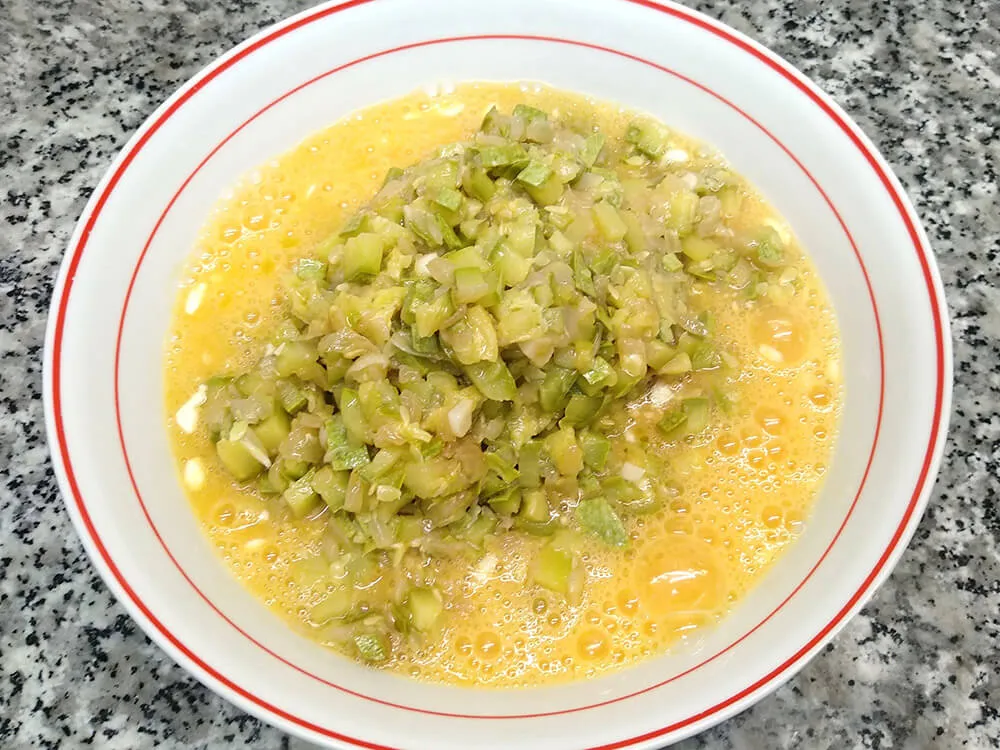 Huevos batidos y calabacín y cebolla cocinados.