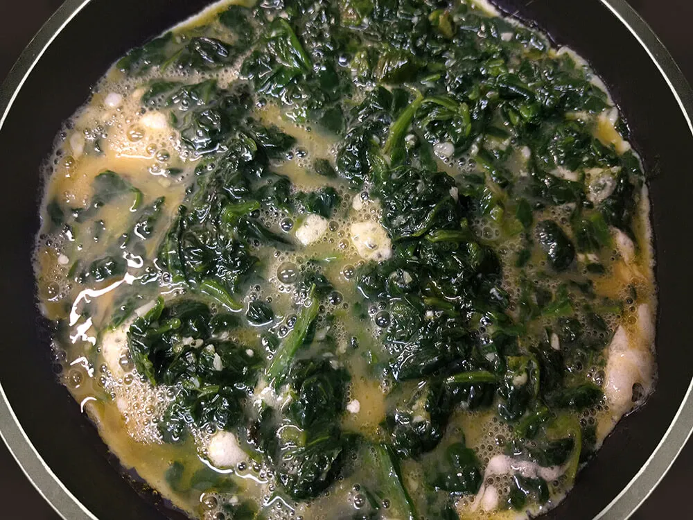 Huevos batidos mezclados con espinacas refritas