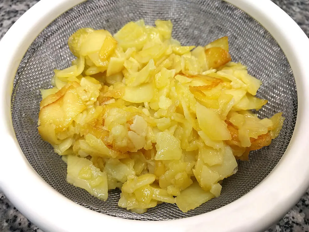 Patatas fritas escurriendo el aceite