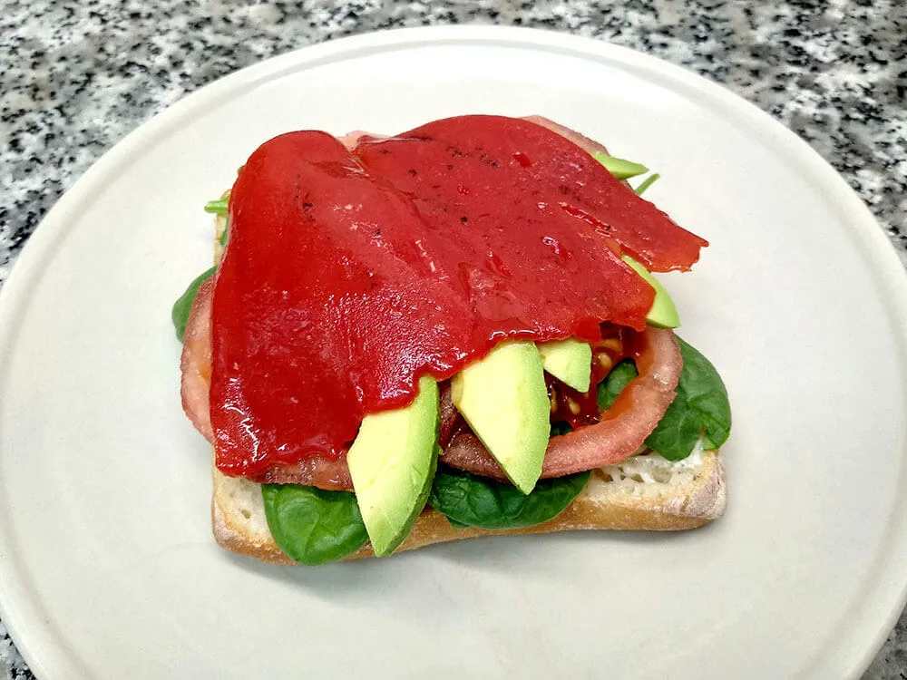 Chapata con mayonesa, espinacas baby, tomate,aguacate y piquillo.